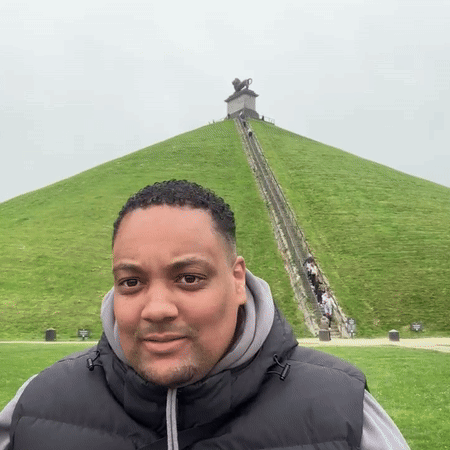 Man in Black Vest on Grassy Hill