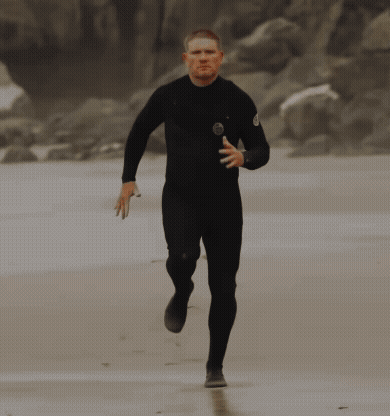 Man in Black Wetsuit Running on Beach