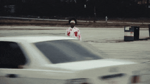 Man In Bloody Shirt Standing In Front Of Car GIF