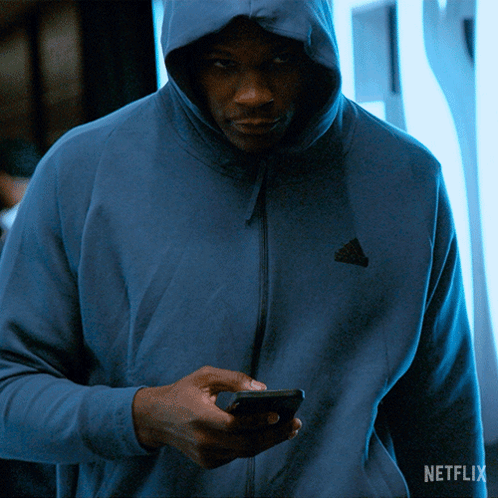 Man in Blue Adidas Hoodie Looking at Phone
