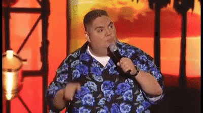 Man in Blue and Black Floral Shirt Holding Microphone Making Funny Face