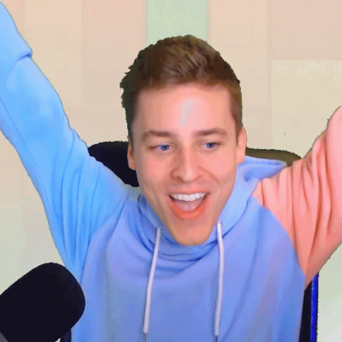 Man In Blue And Pink Hoodie Smiling With Arms Outstretched GIF