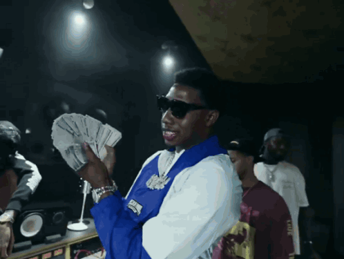 Man in Blue and White Jacket Holding Money
