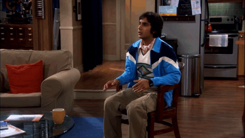 Man in Blue and White Jacket Sitting in Chair