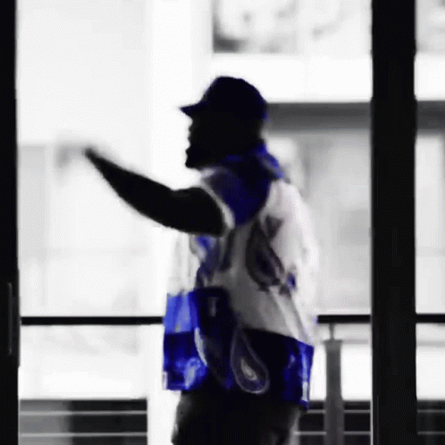 Man in Blue and White Jersey Waving by Window