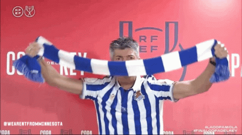 Man in Blue and White Striped Shirt Holding Scarf