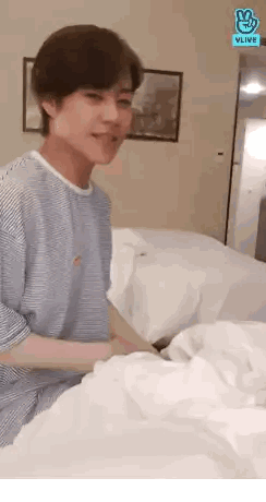 Man in Blue and White Striped Shirt Lying on Bed
