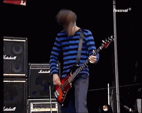 Man in Blue and White Striped Shirt Playing Bass Guitar