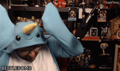 Man In Blue Dinosaur Costume Holding Shure Microphone GIF