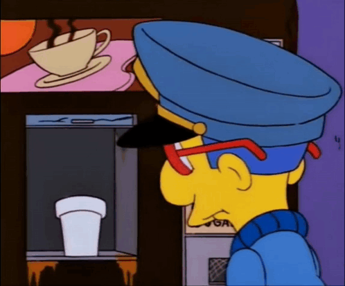 Man in Blue Hat Looking at Coffee Machine