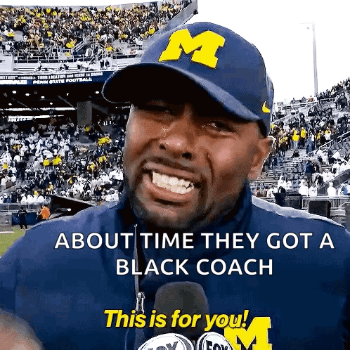 Man in Blue Hat With Letter M Says About Time They Got a Black Coach This Is For You