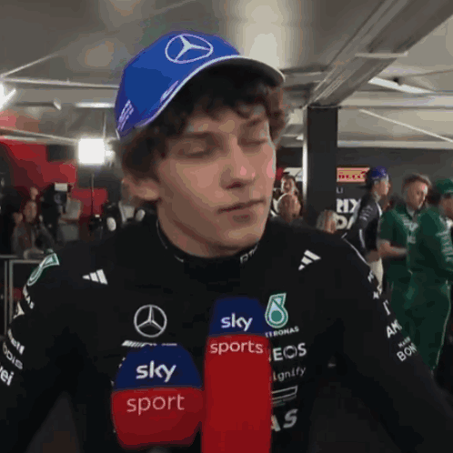 Man in Blue Hat With Mercedes Logo Talking Into Microphone for Sky Sports