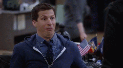 Man in Blue Hoodie and Tie Making Funny Face at Desk
