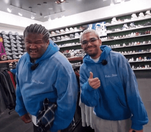 Man in Blue Hoodie Saying Killer Killers Thumbs Up