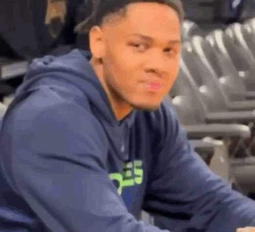 Man In Blue Hoodie Sitting In Stadium GIF
