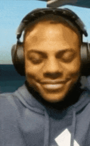 Man in Blue Hoodie Smiling with Headphones
