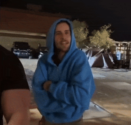 Man In Blue Hoodie Standing In Parking Lot GIF