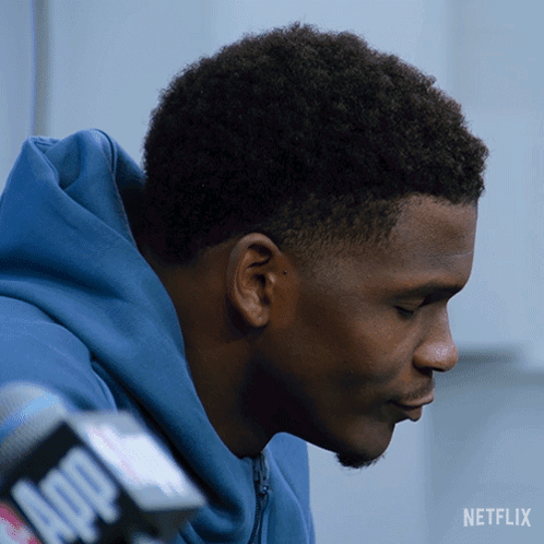 Man in Blue Hoodie Talking Into Microphone