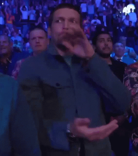 Man in Blue Jacket Applauding in Crowd