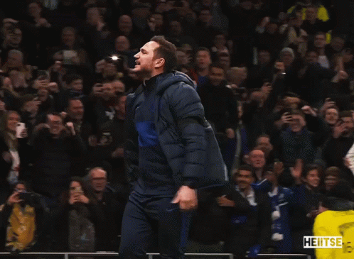 Man In Blue Jacket Dancing In Front Of Crowd With Yellow Vest Saying Heitse GIF