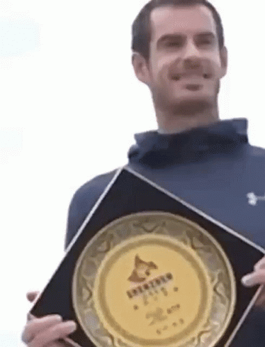Man in Blue Jacket Holding Plaque