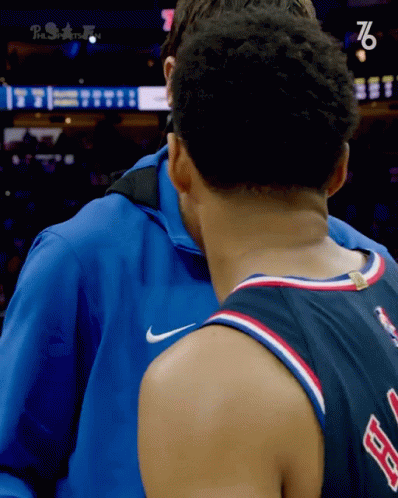 Man in Blue Jacket Hugging 76 Jersey
