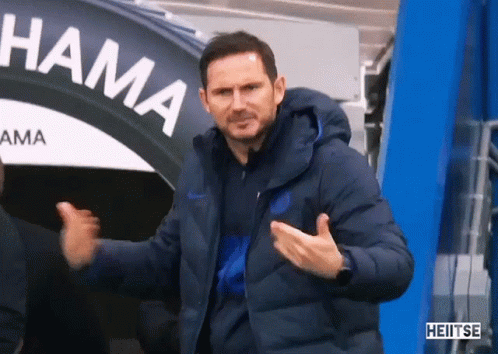 Man in Blue Jacket in Front of Hama Sign