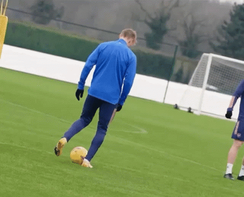 Man in Blue Jacket Kicking Soccer Ball