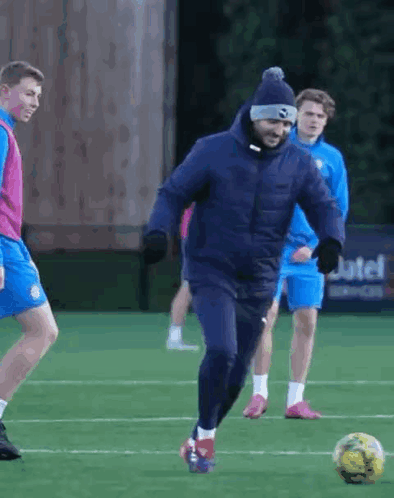 Man in Blue Jacket Kicking Soccer Ball