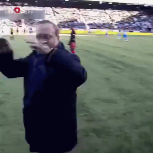 Man in Blue Jacket on Soccer Field