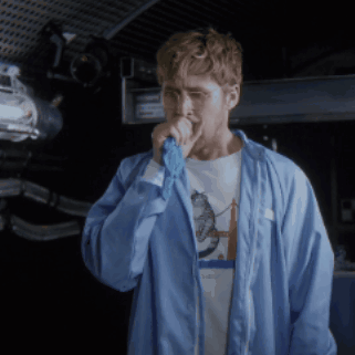 Man In Blue Jacket Singing Into Microphone With Space Shirt GIF