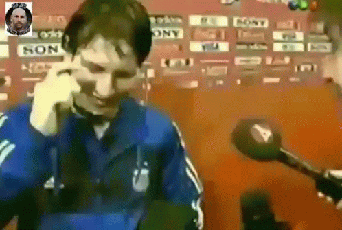 Man in Blue Jacket Talking on Cell Phone with Microphone