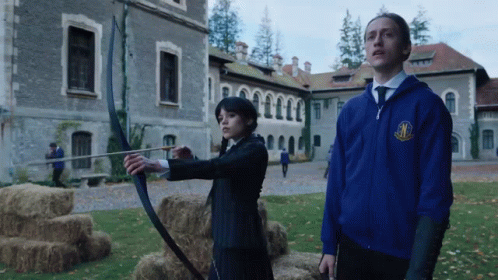 Man in Blue Jacket with M Next to Woman with Bow and Arrow