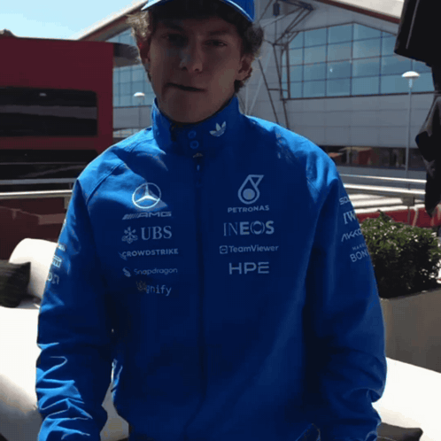 Man in Blue Jacket With UBS and INEOS Sponsors