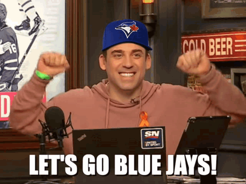 Man in Blue Jays Hat Saying Let's Go Blue Jays in Front of Laptop