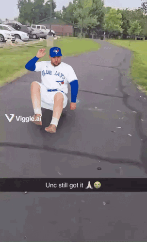 Man in Blue Jays Shirt Sliding Down Road