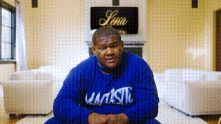 Man in Blue Majestic Sweatshirt Sitting on Floor