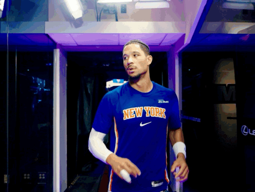 Man in Blue New York Shirt Walking Through Purple Doorway