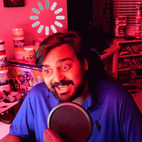 Man in Blue Polo Shirt at Microphone with Loading Screen