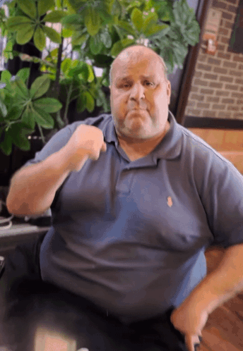 Man In Blue Polo Shirt With Fist Up GIF