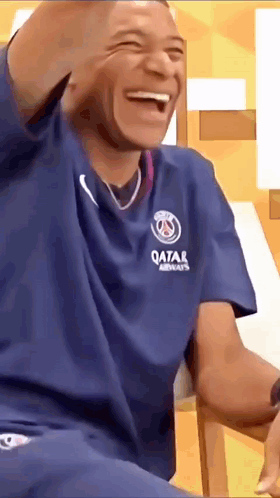 Man in Blue Qatar Airways Shirt Laughing Sitting