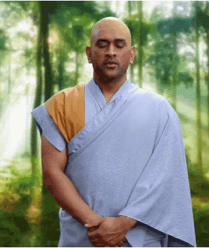 Man in Blue Robe Meditating in Woods