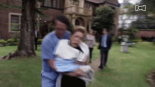 Man in Blue Scrub Carrying Woman in White Towel
