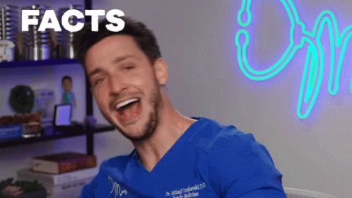 Man In Blue Scrub Laughing In Front Of Facts Sign GIF