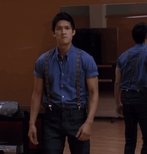 Man in Blue Shirt and Black Jeans Standing Before Mirror