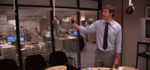 Man In Blue Shirt And Black Tie By Window With Blinds GIF