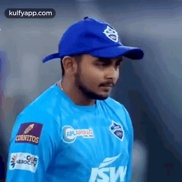 Man in Blue Shirt and Blue Hat Standing on Field