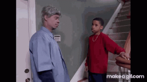 Man in Blue Shirt and Boy in Red Shirt Standing on Stairs