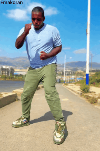 Man In Blue Shirt And Green Pants With Emakoran GIF