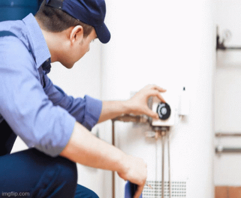 Man in Blue Shirt and Hat Working on Thermostat